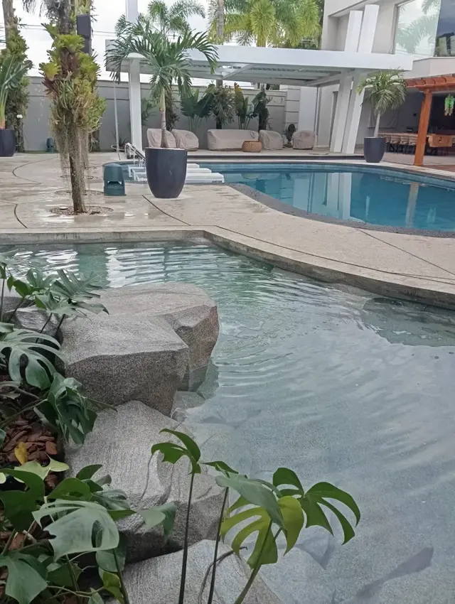 Área de lazer com piscina natural e pedras artificiais