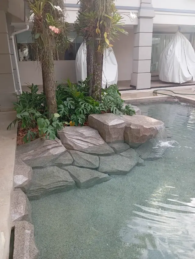 Piscina natural com pedras artificiais e vegetação